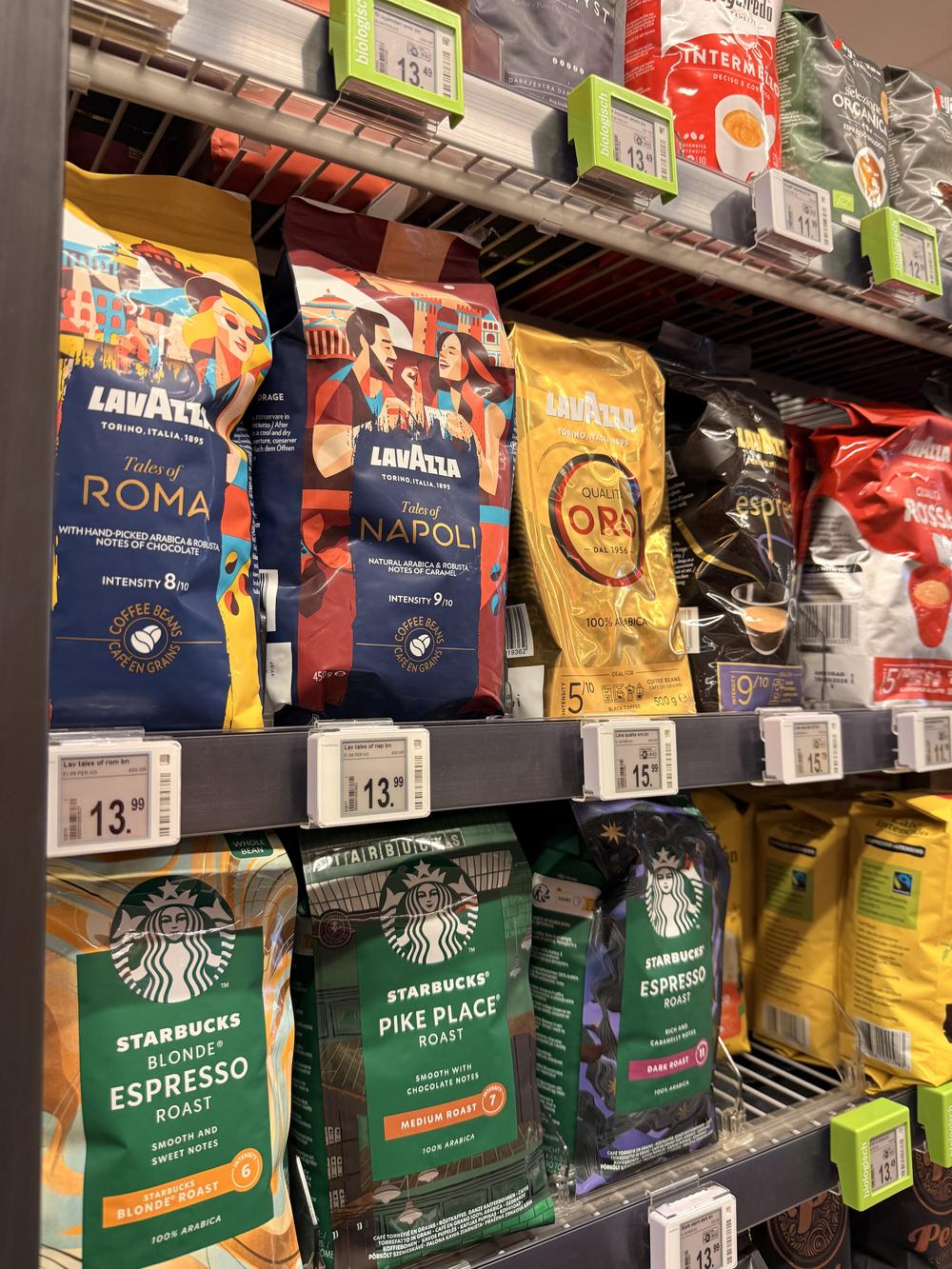 Supermarkt koffiebonen in het schap met Lavazza, Starbucks en Segafredo